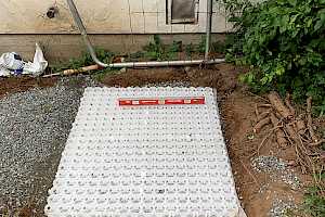 Pl.ace and level the foundation grid. Note the membrane attached to the foundation grid which serves as a weed suppresent.